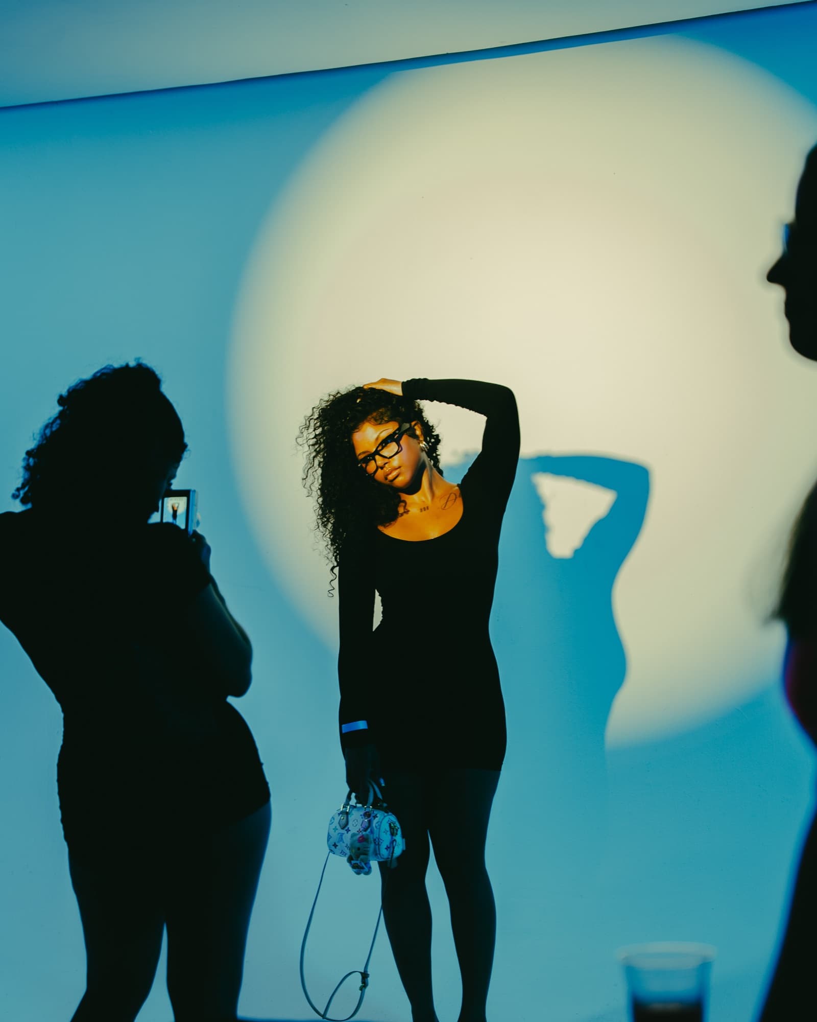A silhouette posing in front of a spotlight backdrop