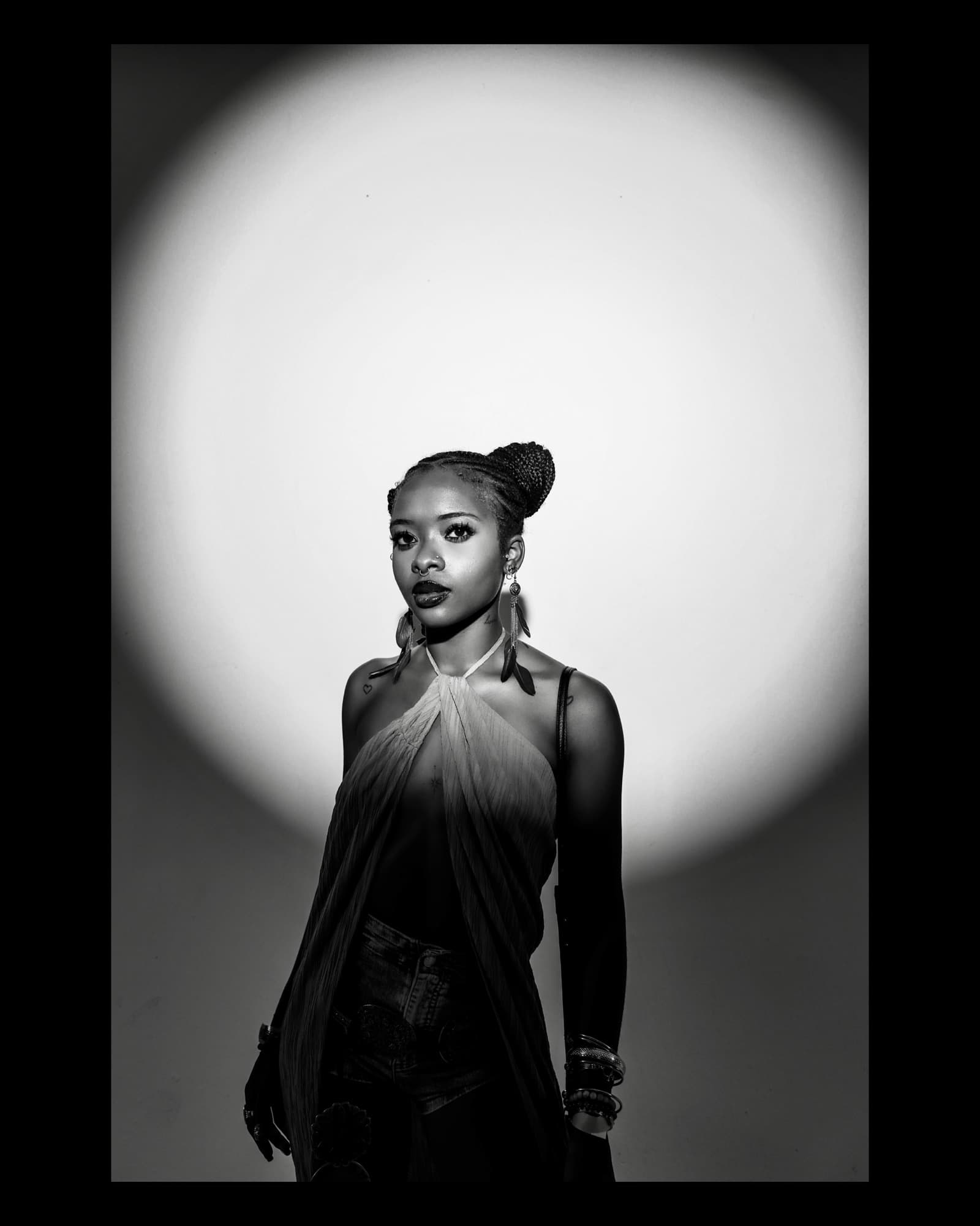 A portrait in a white circle of light, in black and white